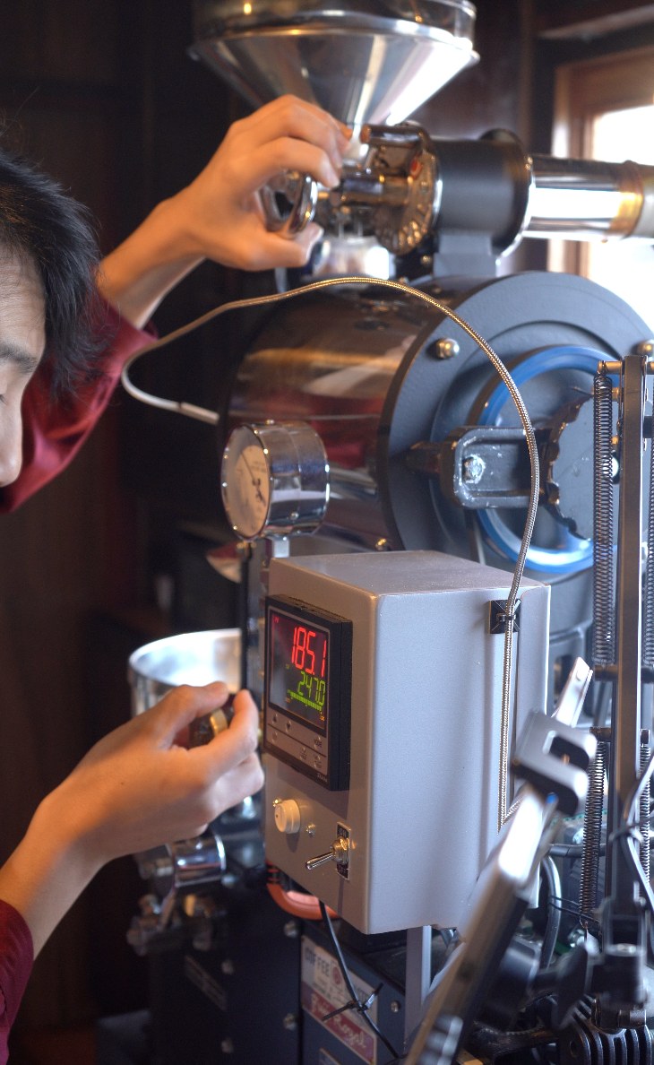 サンプルスプーンを使って焙煎中の豆を確かめる様子